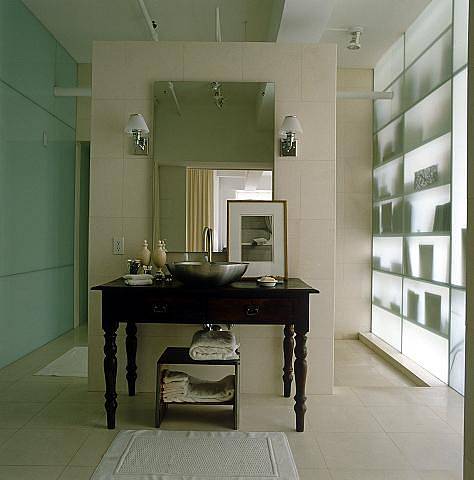 Tmavou koupelnu prosvětluje průsvitná stěna a zrcadlo nad umyvadlem