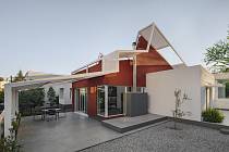 Dům má netradiční tvar i falešnou kovovou střechu