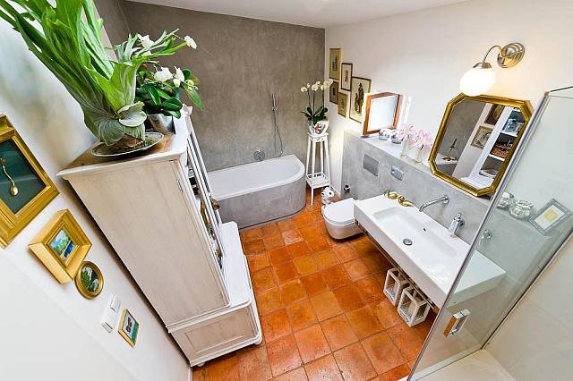 Koupelna je vybavená moderní sanitou a sprchovým koutem. Koupelna je zařízená starou kredenc v bílé barvě. 