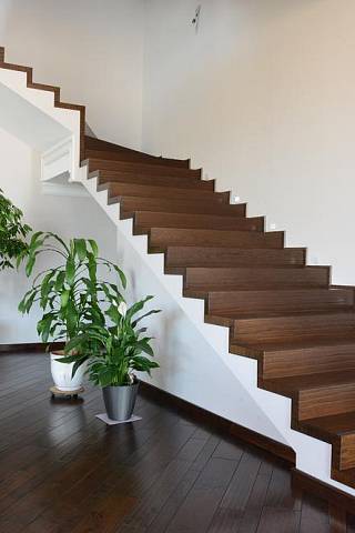 Toto betonové schodiště je nádherně a designově velmi čistě obložené dřevem a vytváří dominantu prostoru. Chybí zde však vnější zábradlí kvůli bezpečnosti, takže bychom toto schodiště nevolili pro rodinu s malými dětmi. Foto: Shutterstock.com...