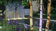 Knightsbridge Urban zahrada z květinové výstavy v Chelsea, Velká Británie. Na této zahradě dominuje bazén s vodopádem, který je obklopen z obou stran pruhy trávníku a záhony s břízami, kosatci, okrasným česnekem a dalšími letničkami.