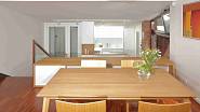 Dům má několik výškových úrovní, obývací pokoj s velkým jídelním stolem je nad úrovní kuchyně.