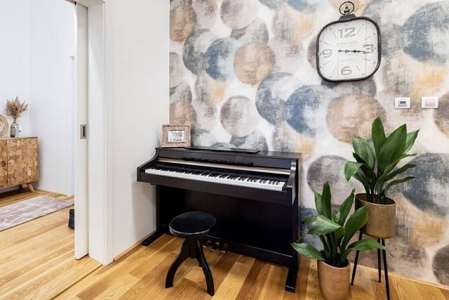 Klavír, na který hraje majitelka i dcery, v chodbě nikomu nepřekáží a navíc se stal přirozeným centrem bytu.