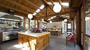 Kuchyně má  místo dřeva na podlaze keramické matové dlaždice a kuchyňská linka v nerez provedení i ve své modernosti vzbuzuje představu jakési rustikálnosti a starobylosti.