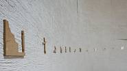 Na hrubé stěně kostela je čtrnáct drobných zastavení křížové cesty. Leštěné bronzové reliéfy byly vyřezány vodním paprskem podle kreseb Vladimíra Kokolii. FOTO: BoysPlaysNice.