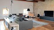 Obývacímu pokoji, laděnému do šedé a bílé, dominuje stojací lampa Constanza (design Paolo Rizzatto; Luceplan).