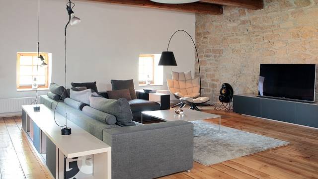Obývacímu pokoji, laděnému do šedé a bílé, dominuje stojací lampa Constanza (design Paolo Rizzatto; Luceplan).