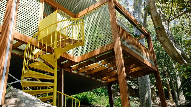 Žluté kovové schodiště je základní vstup domu