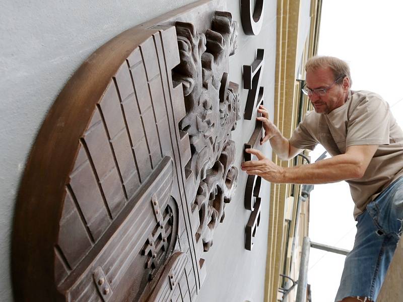 Akademický sochař Libor Pisklák instaluje označení na budovu Městského úřadu v Litoměřicích na Mírovém náměstí
