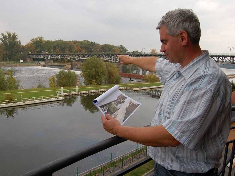 Jiří Šikula ze společnosti Povodí Labe ukazuje místo, kde by plánovaná vodní elektrárna měla stát. V ruce drží počítačovou studii vodního díla. 