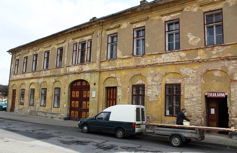 Číslo popisné 1. Na jižní straně bohušovického Husova náměstí stojí památkově chráněný pozdně empírový zájezdní hostinec z roku 1849. Dům s číslem popisným 1, ve kterém se nachází truhlářská dílna, je v současné době v soukromých rukou.