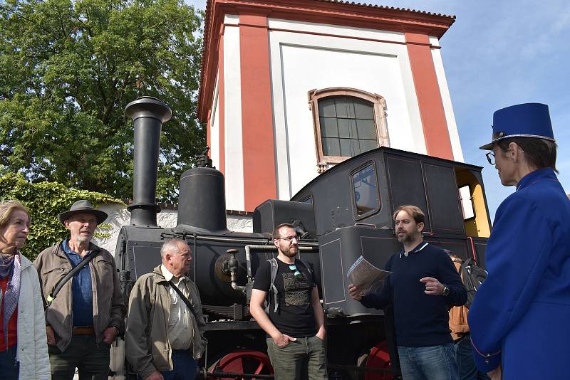 Procházka vedla do Kavárny s párou po bývalé železniční stanici. Před ní je historická lokomotiva. U ní jsou na záběru historici Filip Hrbek (uprostřed) a Jen Peer (druhý zprava).