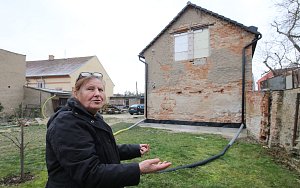 Hana Kadlecová ukazuje zahradu, hraničící s pozemkem souseda.
