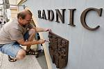 Akademický sochař Libor Pisklák instaluje označení na budovu Městského úřadu v Litoměřicích na Mírovém náměstí