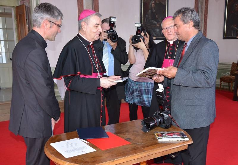 Fotograf Litoměřického Deníku Karel Pech (vpravo) předal arcibiskupovi Giuseppe Leanzovi svou knihu s fotografiemi z loňské povodně na Litoměřic