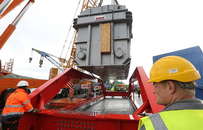Obří díl regulačního transformátoru v Lovosicích přeložili odborníci z lodě na nákladní automobil.