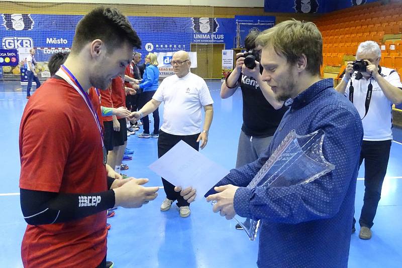 Jiří Motl předává pohár kapitánovi vítězného týmu z Rožnova