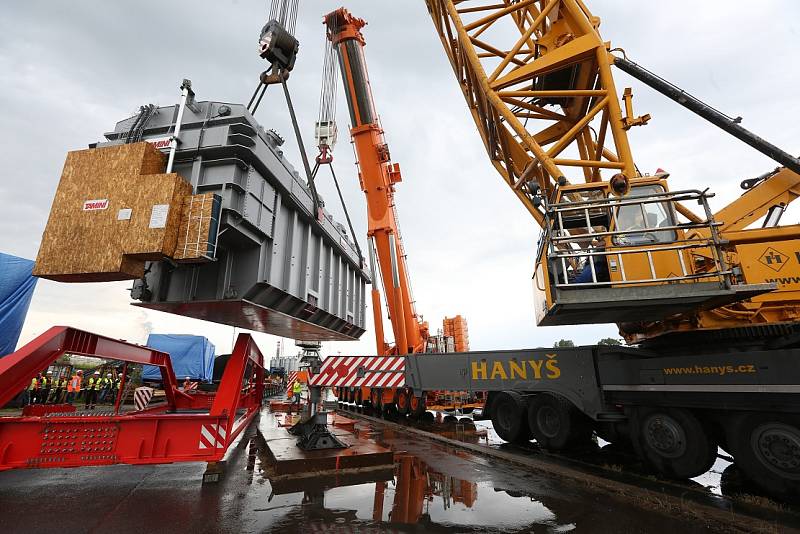 Obří díl regulačního transformátoru v Lovosicích přeložili odborníci z lodě na nákladní automobil.