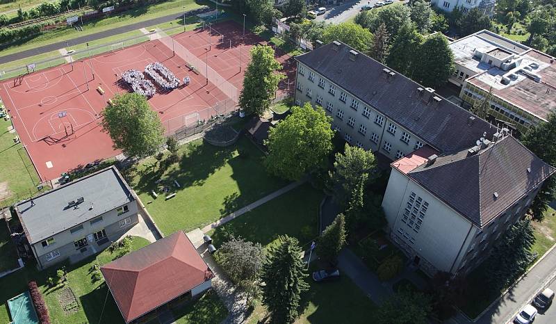 POHLED Z VRTULNÍKU. Ve sportovním areálu Masarykovy základní školy Litoměřice se na dopředu nakreslenou číslici 80 ve středu ráno postavilo na pět set dětí a dospělých.