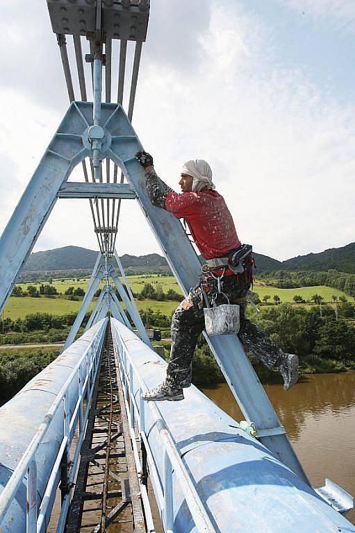 PAVOUČÍ MUŽI odvádějí špinavou práci na natírání mostu pro vodovodní potrubí ve výšce 15 až 40 metrů nad hladinou Labe. Provedení kompletní údržby potrvá měsíce. 