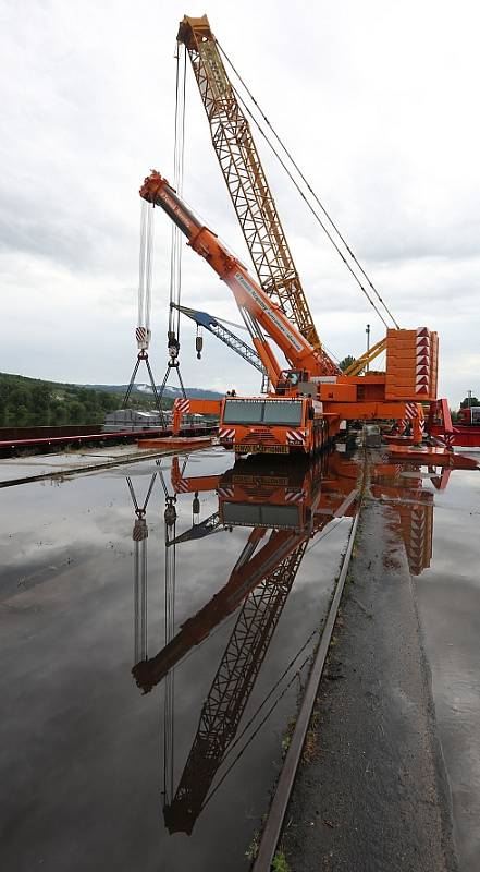 Obří díl regulačního transformátoru v Lovosicích přeložili odborníci z lodě na nákladní automobil.