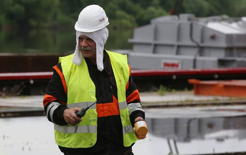 Obří díl regulačního transformátoru v Lovosicích přeložili odborníci z lodě na nákladní automobil.