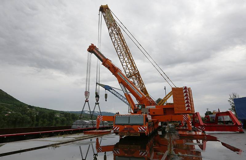 Obří díl regulačního transformátoru v Lovosicích přeložili odborníci z lodě na nákladní automobil.