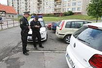 Městští strážníci udělují pokutu za parkování na chodníku v Ladově ulici.