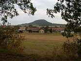 Obec Vražkov a za ní je hora Říp.