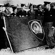 První vrchní velitel ozbrojených sil NATO v Evropě generál Dwight D. Eisenhower pózuje u původní vlajky aliance