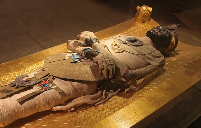 Starověká mumie v turistické atrakci v egyptské vesnici nedaleko Káhiry, tělo mumie vystavené jako turistická atrakce mezi dalšími starými artefakty.