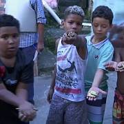 Děti z Ria de Janeira ukazují nalezené nábojnice pocházející z pouličních přestřelek