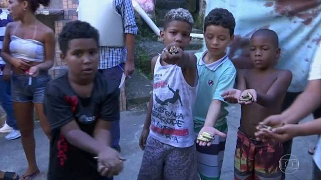 Děti z Ria de Janeira ukazují nalezené nábojnice pocházející z pouličních přestřelek