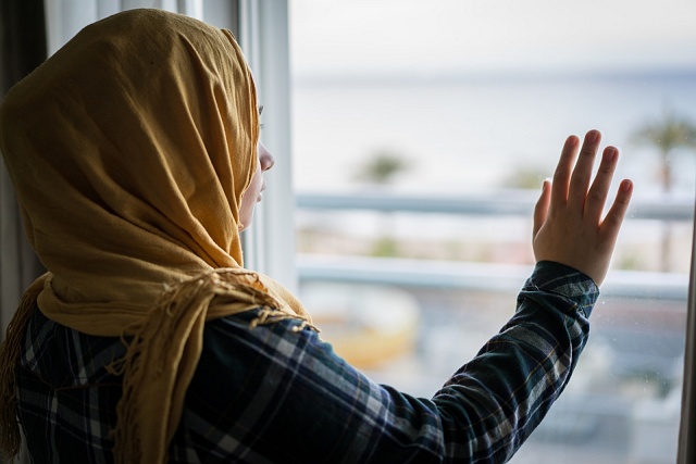 Muslimská žena se dívá z okna