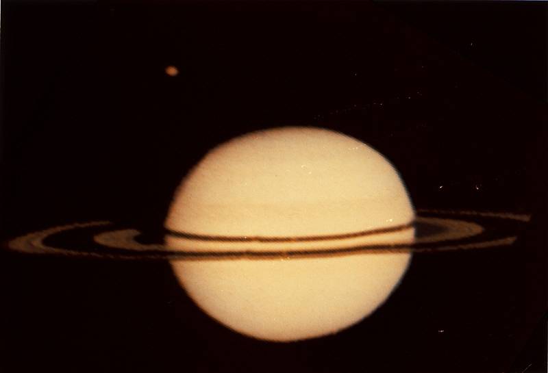 Pioneer 11, první sonda ze Země, která dosáhla oblast Saturnu. Na snímku planeta spolu s měsícem Titanem (v levé horní části). Foto z roku 1979.