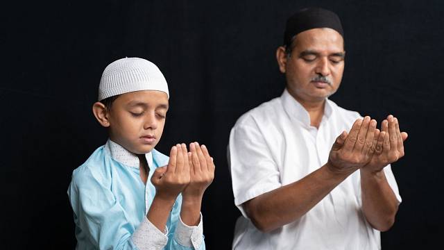 Otec a syn při modlitbě.