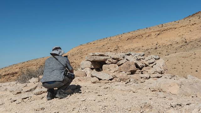 Muž fotografující starobylou beduínskou past na leopardy v Negevu