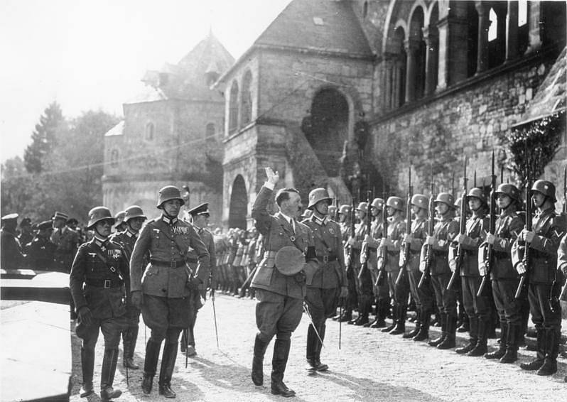 Erwin Rommel (vpředu vlevo) doprovází Adolfa Hitlera v roce 1934