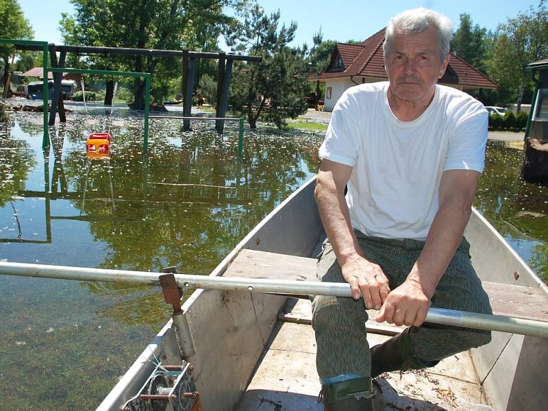 Přemysl Hála, správce kempu U Hráze na břehu Nechranické přehrady, projíždí areálem na loďce