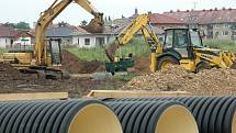 Stavební stroje pracují na výkopu pro kanalizaci poblíž stadionu Flóra v Žatci, kde se v současné době připravují sítě pro dalších 18 stavebních parcel. 