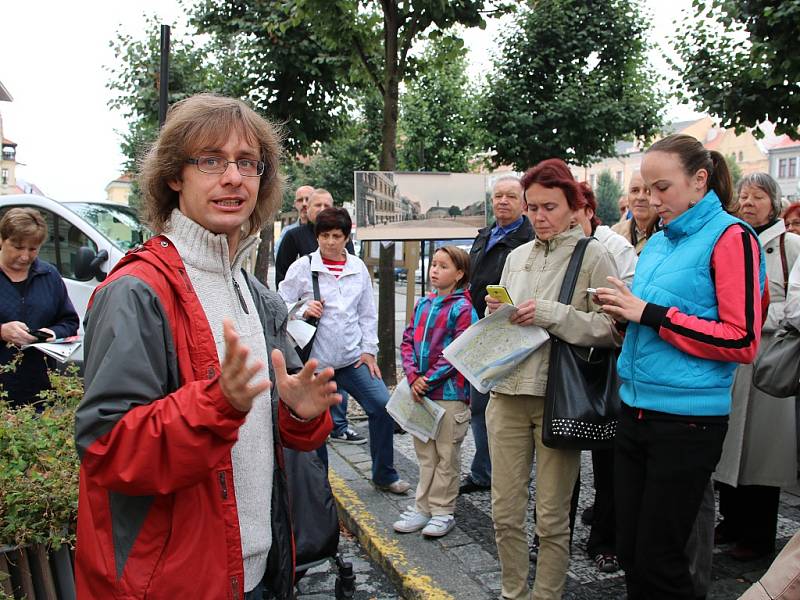 Odborník na novodobou historii Martin Vostřel (v červeném) při komentované prohlídce historických pohlednic na Mírovém náměstí v Lounech