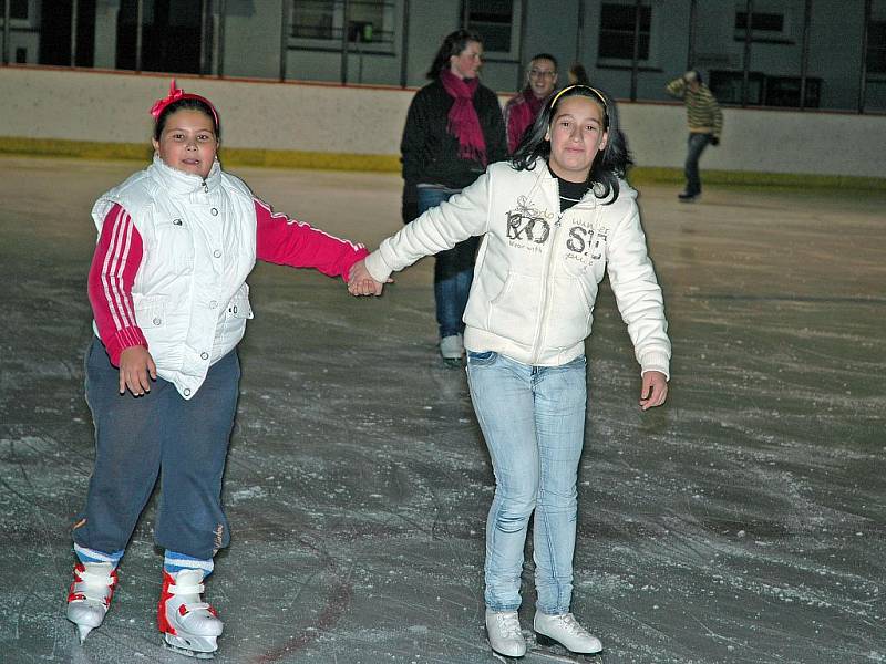 Sestřenice Jarmila a Eva Feriovy si obouvají brusle při veřejném bruslení na zimním stadionu v Lounech.