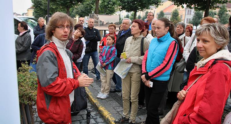 Odborník na novodobou historii Martin Vostřel (v červeném) při komentované prohlídce historických pohlednic na Mírovém náměstí v Lounech