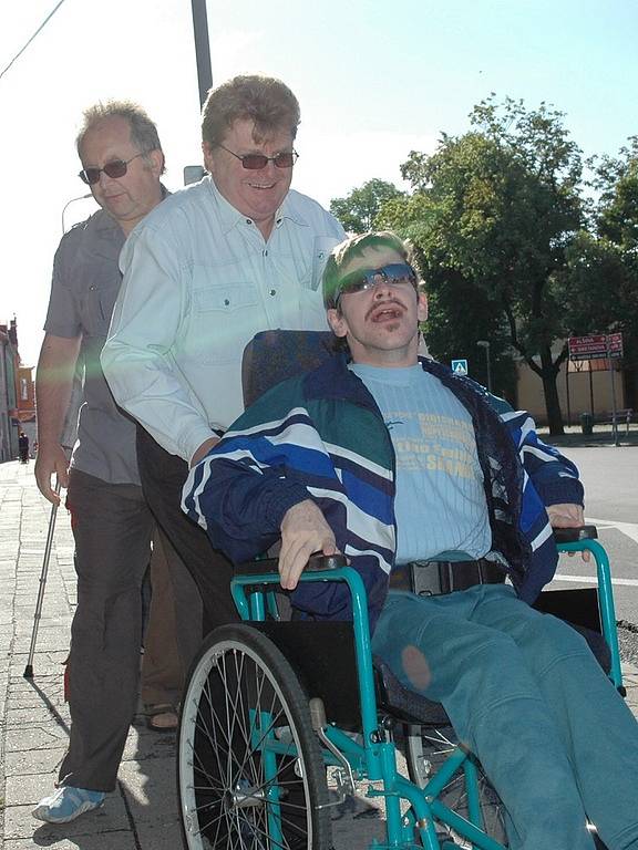 Zastupitel Petr Říha tlačí vozík s Lukášem Řehákem, přihlíží chlapcům otec František.