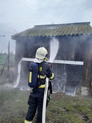 Hasiči likvidují požár zahradní chatky v Dobroměřicích.