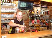 Eva Výšková ve sportovním baru v Žatci v Pražské ulici nalévá tequilu do skleniček. 