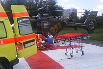Záchranáři nakládají zraněného motokrosaře do vrtulníku