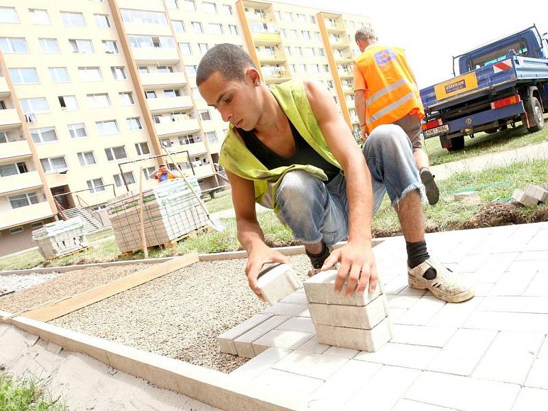 Rekonstrukce chodníků na sídlišti v Žatci, Jan Kanči pokládá novou dlažbu. 