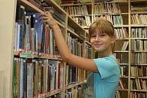 Markéta Malá si prohlíží knížky v nově otevřené knihovně v Lounech krátce po zahájení provozu v srpnu 2010.