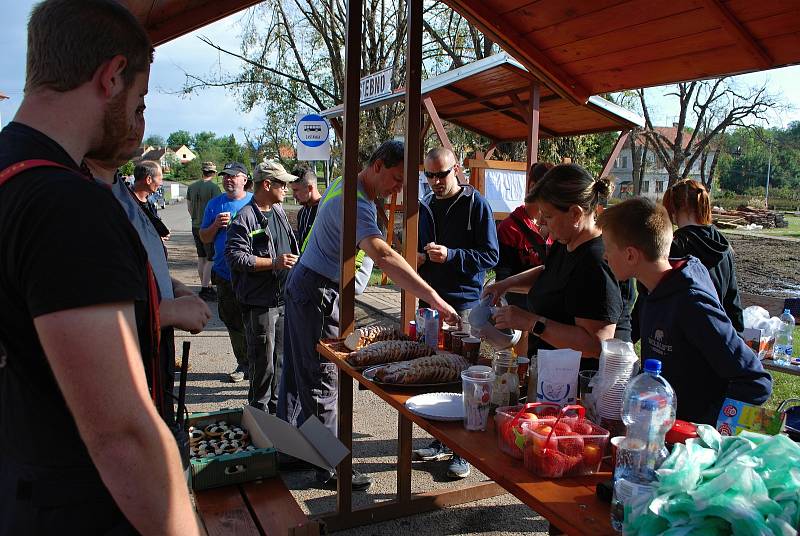Sobota 3. července v obci Stebno na Lounsku. Místní ženy hostí pomocníky.